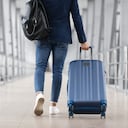 Unrecognizable Man With Bag And Suitcase Walking In Airport Terminal, Rear View Of Young Male On His Way To Flight Boarding Gate, Ready For Business Travel Or Vacation Journey, Cropped, Copy Space