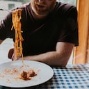 Una persona comiendo pastas - Imagen de referencia