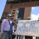 Supporters of slain Ecuadorean presidential candidate Fernando Villavicencio, display a placard reading "They Killed Our President. Cowards" outside the Vertical Cemetery in Quito, during his funeral on August 10, 2023, a day after his assassination. Villavicencio, the second most popular candidate in the presidential race according to recent opinion polls, was shot dead while leaving a rally in the nation's capital on Wednesday, prompting President Guillermo Lasso to declare a state of emergency and blame the assassination on organized crime. Villavicencio, a 59-year-old anti-corruption crusader who had complained of receiving threats, was murdered as he was leaving a stadium in Quito after holding a campaign rally, officials said. (Photo by Rodrigo BUENDIA / AFP)