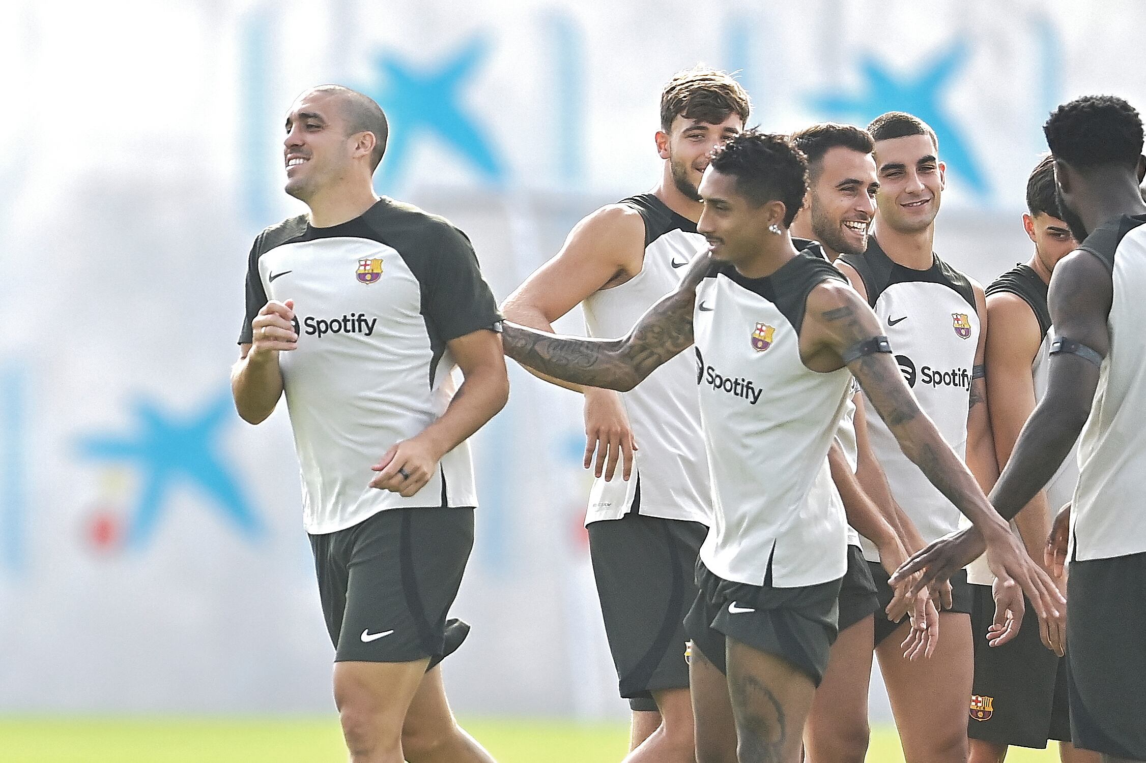 Barcelona�s Spanish midfielder Oriol Romeu (L) is welcomed by teammates during a training session at the Joan Gamper training ground in Sant Joan Despi, near Barcelona, on July 19, 2023. (Photo by Pau BARRENA / AFP)