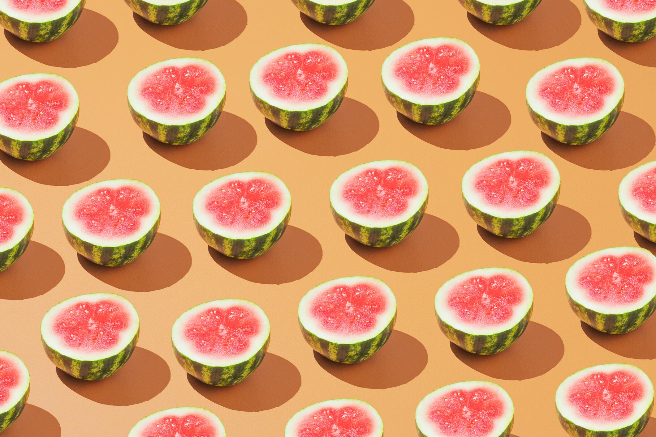 Medias sandías colocadas en un patrón sobre un fondo colorido