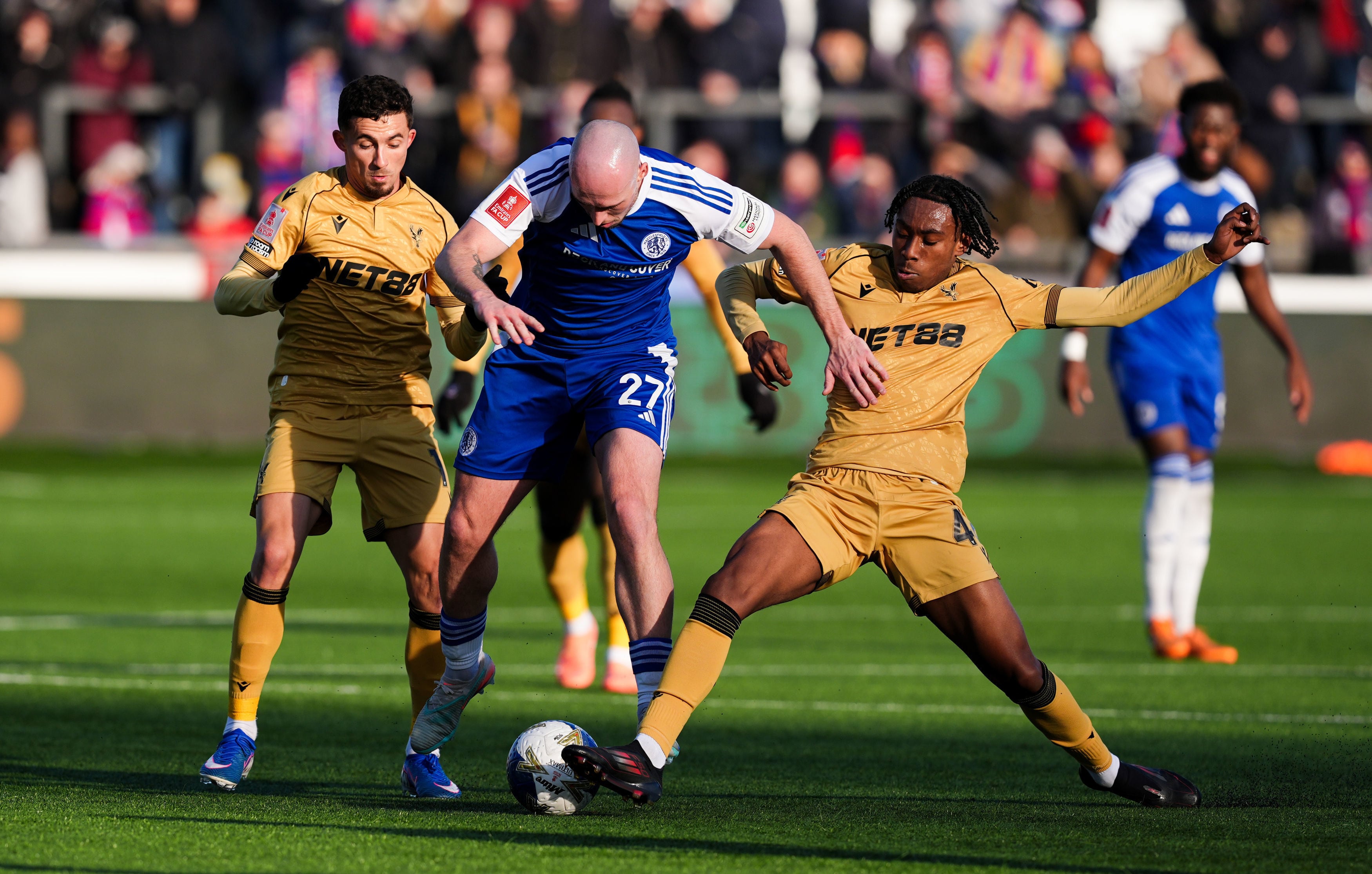 Macclesfield Town's Josh Kay, center and Crystal Palace's Kaden Rodney vie for the ball, during the FA Cup third round soccer match between Macclesfield Town and Crystal Palace, at the Leasing.com Stadium, Macclesfield, England, Saturday, Jan. 10, 2026. (Martin Rickett/PA via AP)