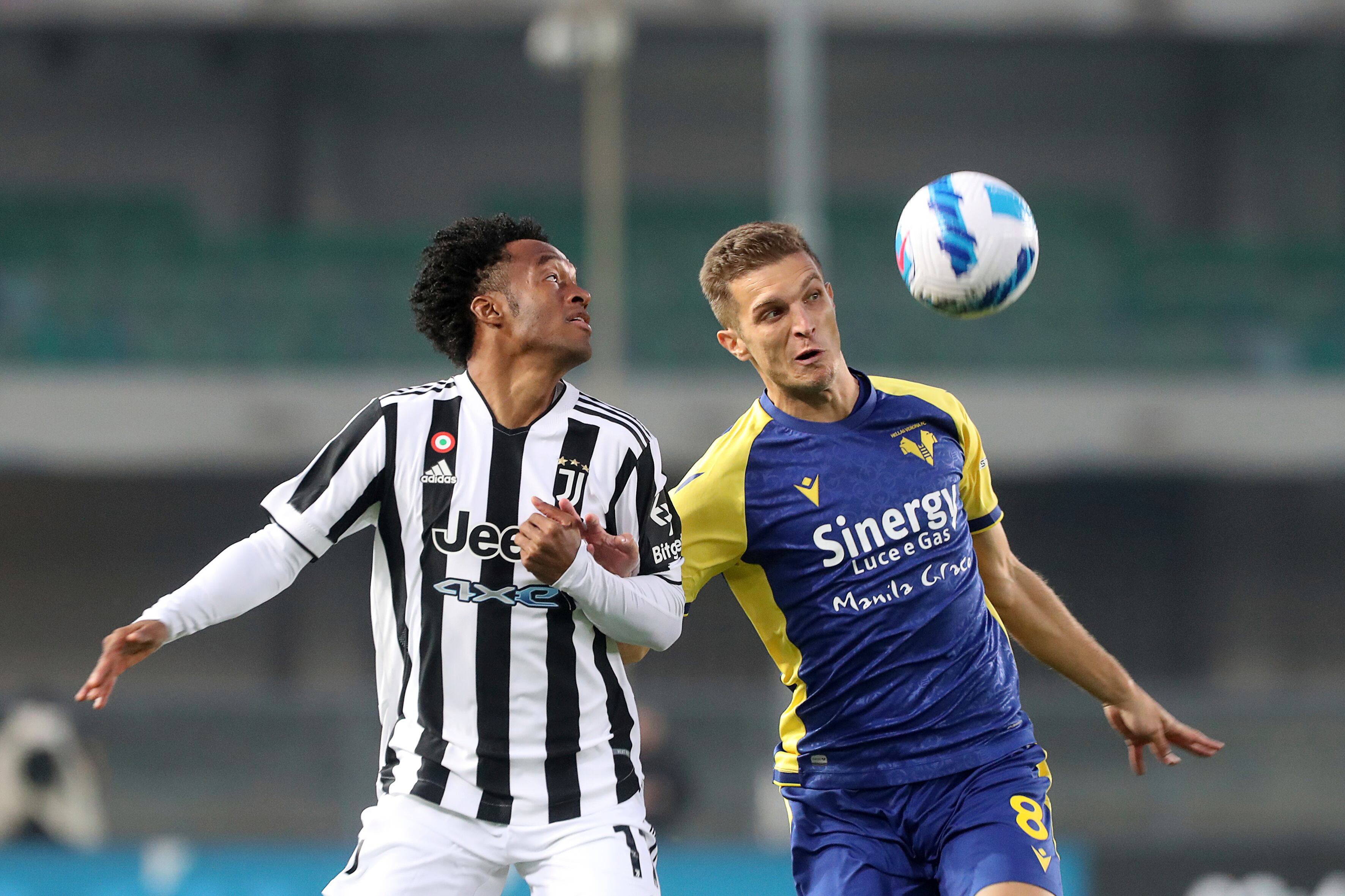Verona's Darko Lazovic, right, and Juventus' Juan Cuadrado challenge for the ball during the Serie A soccer match between Hellas Verona and Juventus, at the Verona Bentegodi stadium, Italy, Saturday, Oct. 30, 2021. (Paola Garbuio/LaPresse via AP)