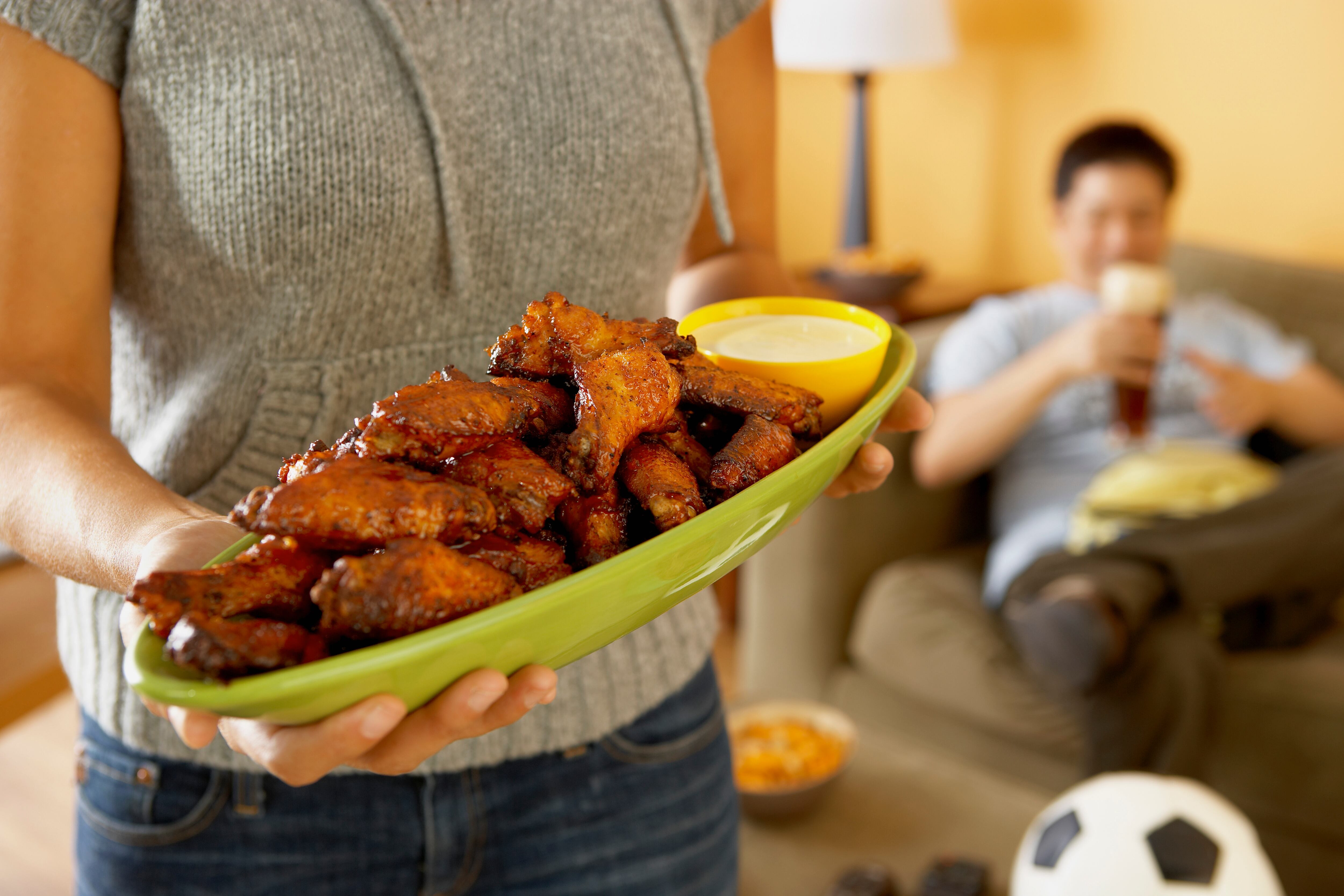 Woman holding platter of buffalo wings