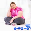 Mujer con sobrepeso deprimida sentada en el suelo y no quiere hacer ejercicio.