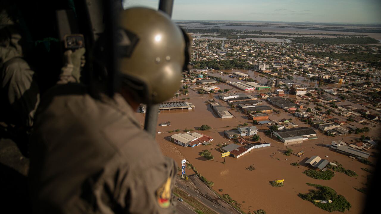 Un militar observa desde un helicóptero las calles inundadas de la ciudad de El Dorado do Sul, estado de Rio Grande do Sul, Brasil, el 8 de mayo de 2024.