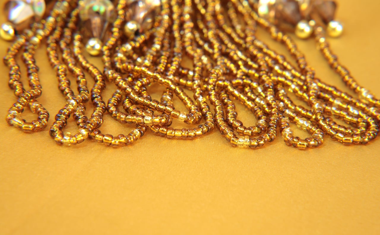 Gold iridescent beads and sequins on a gold background.