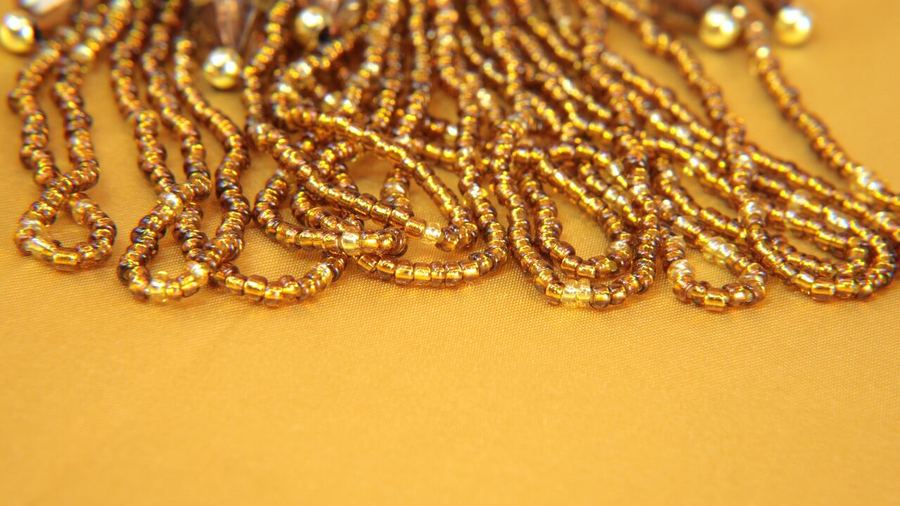 Gold iridescent beads and sequins on a gold background.