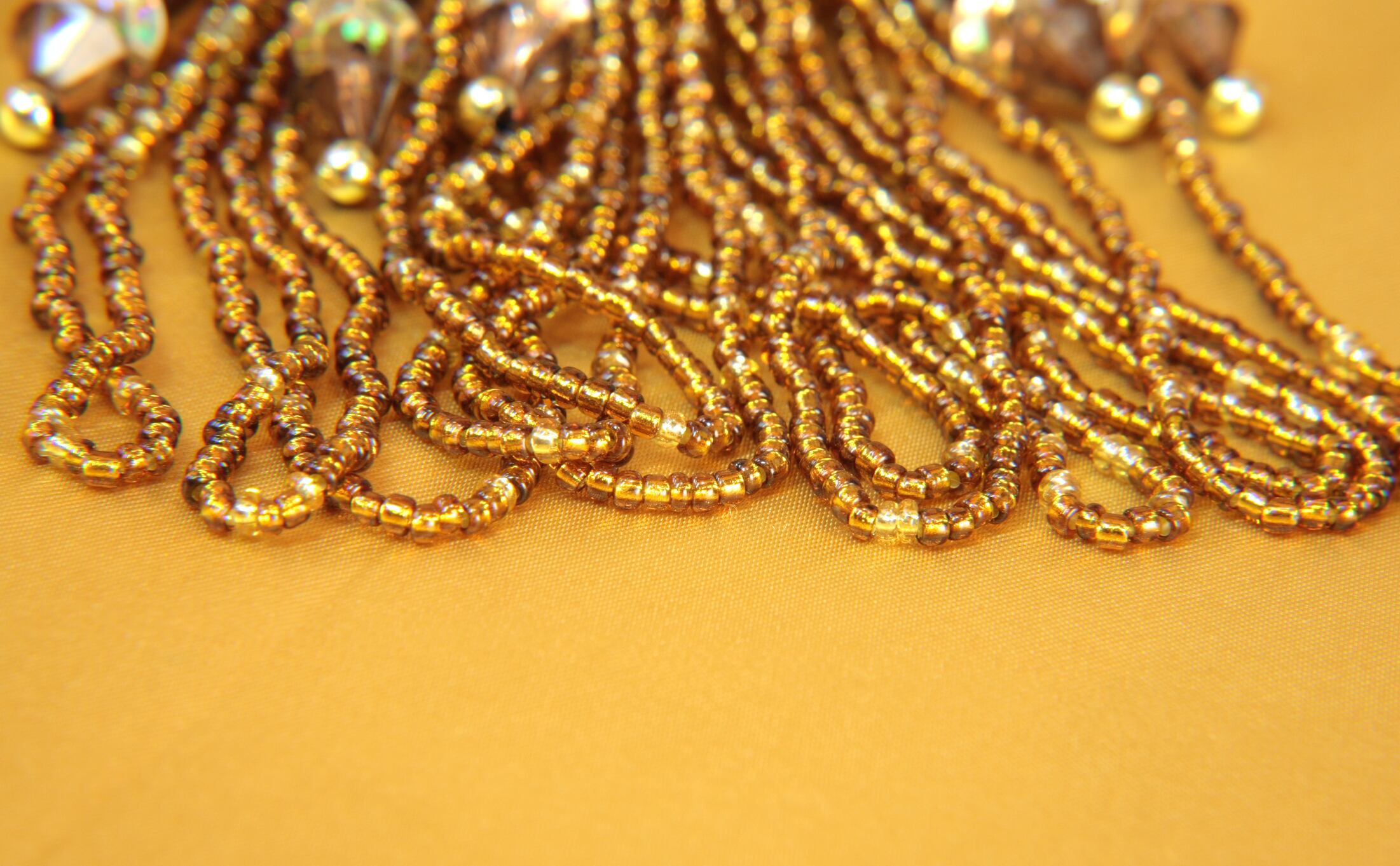 Gold iridescent beads and sequins on a gold background.