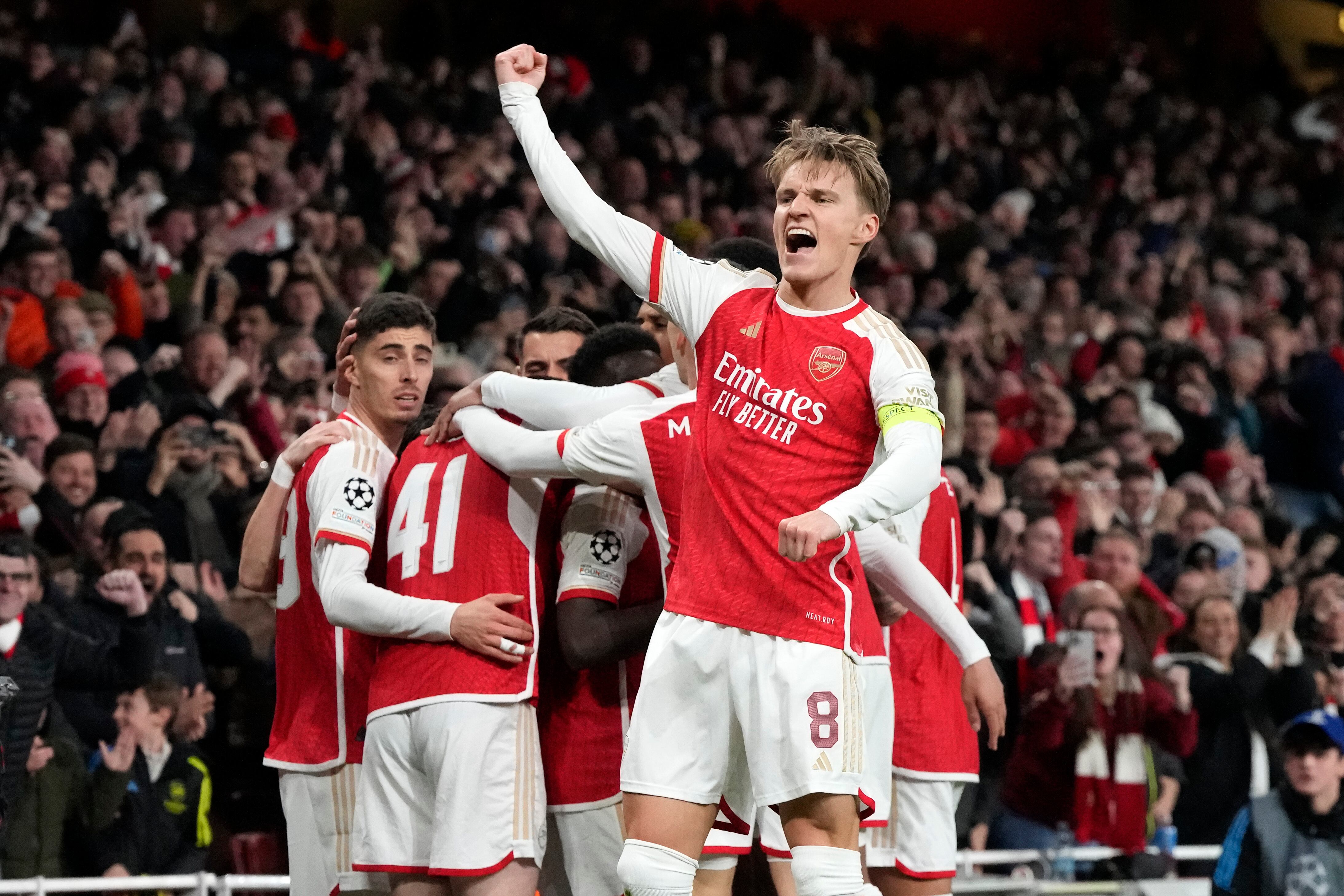 Arsenal's Martin Odegaard, center, celebrates after Bukayo Saka scored the opening goal during the Champions League quarter final first leg soccer match between Arsenal and Bayern Munich at the Emirates Stadium, London, Tuesday, April 9, 2024. (AP Photo/Frank Augstein)