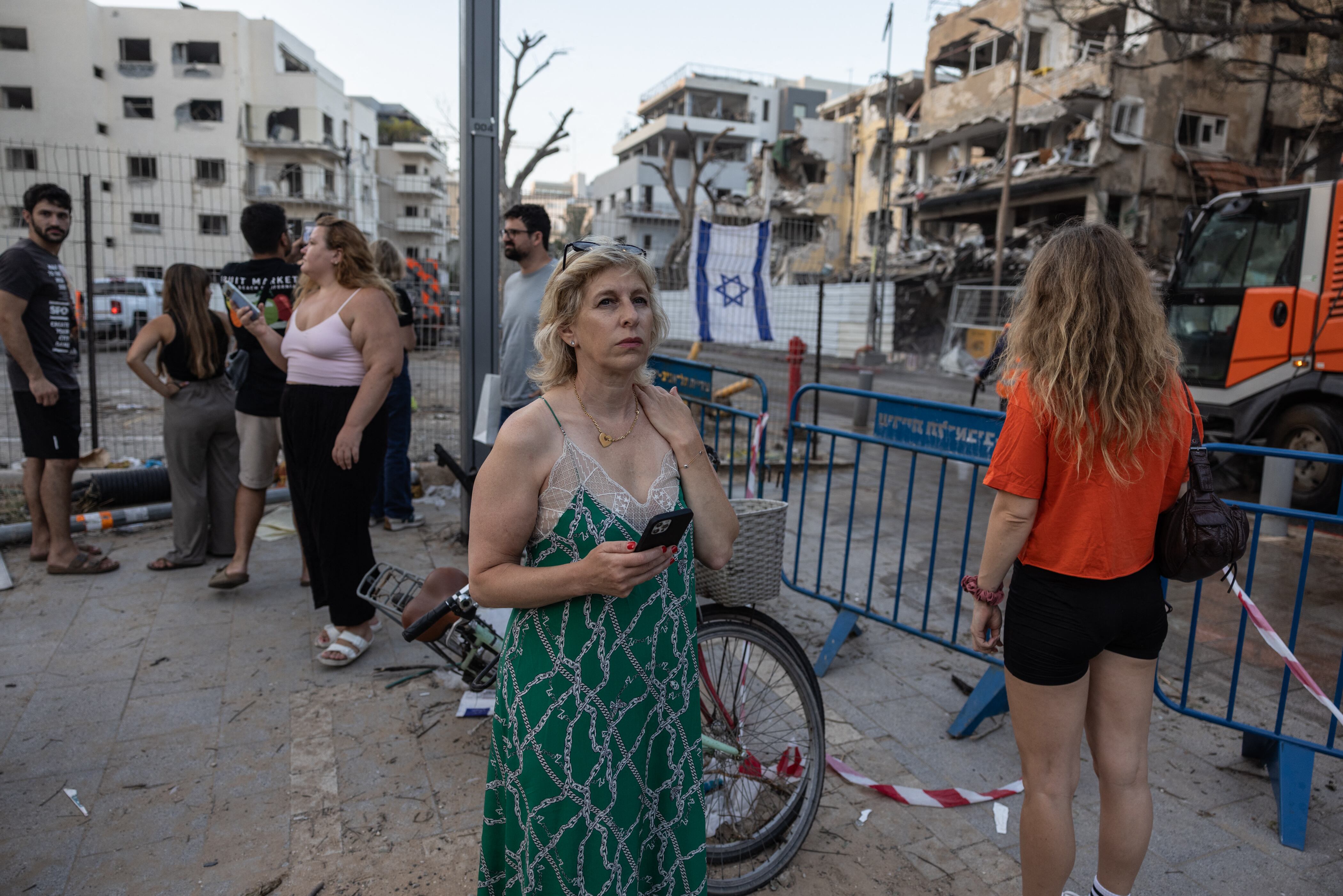Personas visitan el lugar de un ataque con misiles iraníes en el centro de Tel Aviv, que dejó varios edificios destruidos, el 16 de junio de 2025.