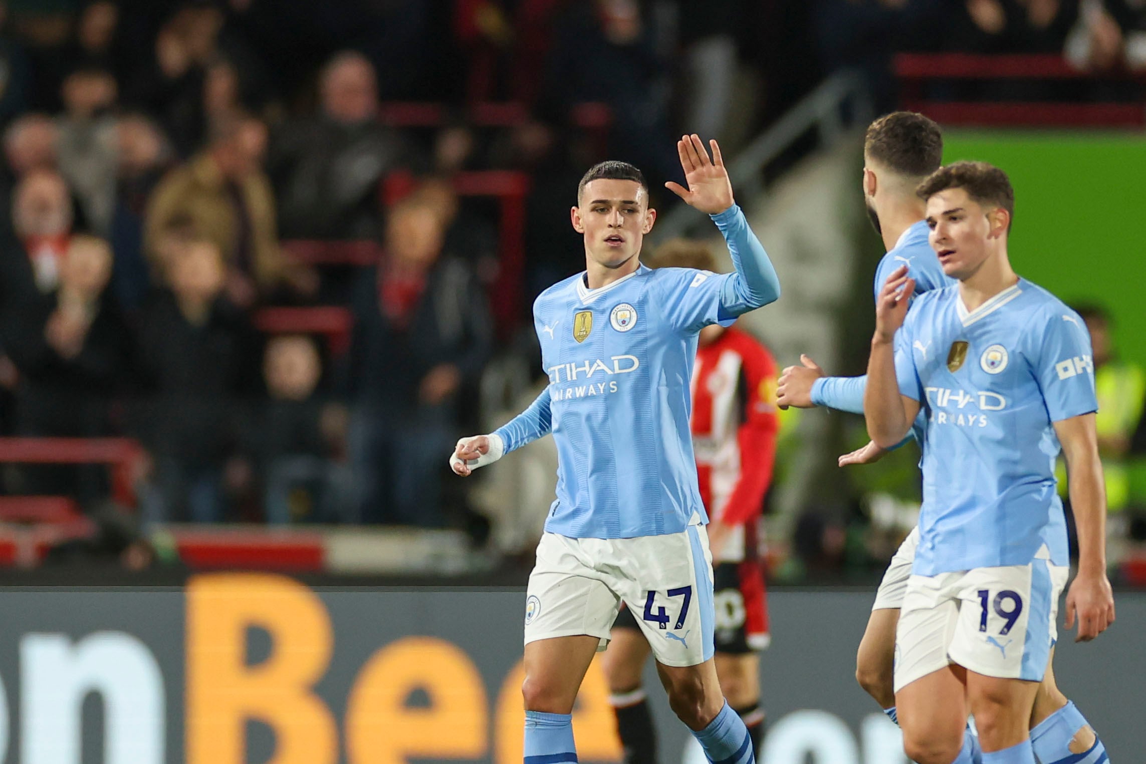 Phil Foden, izquierda, del Manchester City, celebra después de anotar el primer gol de su equipo durante el partido de fútbol de la Liga Premier inglesa entre Brentford y Manchester City en el Gtech Community Stadium de Londres, el lunes 5 de febrero de 2024. (Foto AP/Ian Walton)