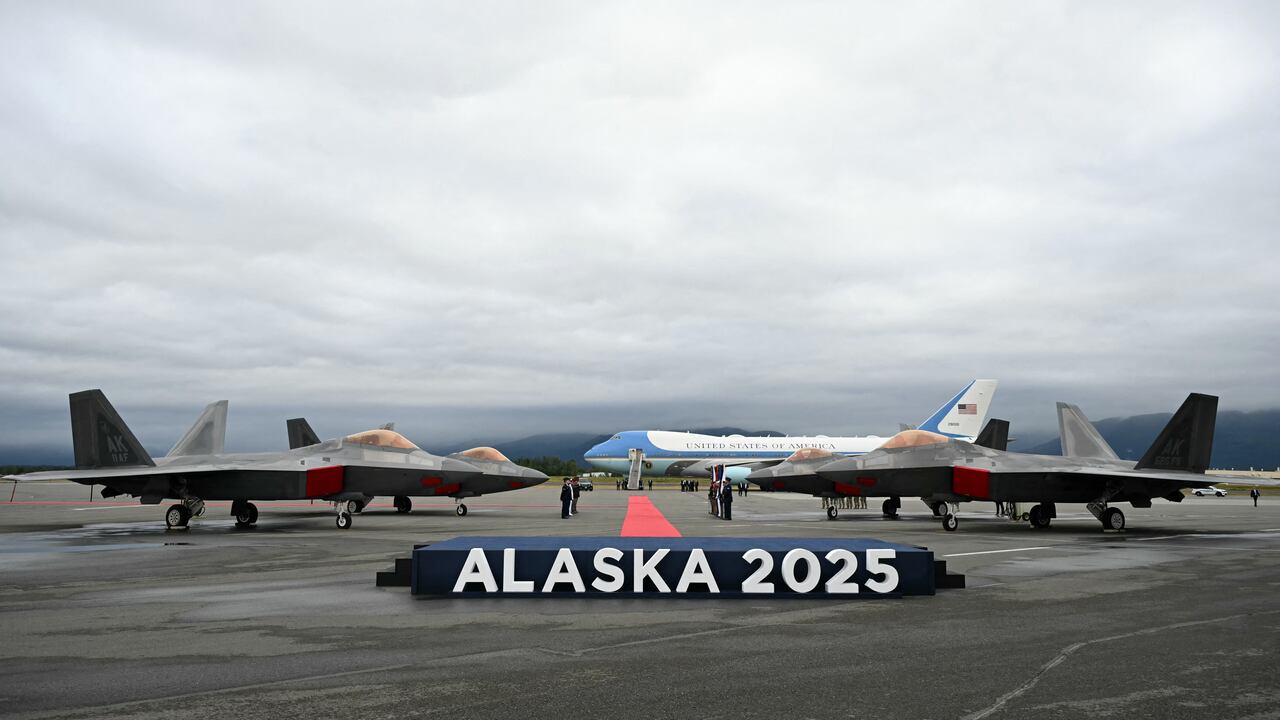 Se ven aviones de combate F-22 en la pista con el Air Force One en la distancia después de que el presidente estadounidense Donald Trump aterrizara en la base conjunta Elmendorf-Richardson en Anchorage, Alaska, el 15 de agosto de 2025. El presidente estadounidense Donald Trump aterrizó en la base militar de Alaska para una cumbre muy esperada con su homólogo ruso Vladimir Putin para presionar para que se ponga fin a la sangrienta guerra de Moscú en Ucrania