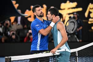 El serbio Novak Djokovic (izq.) abraza al español Carlos Alcaraz tras su partido de cuartos de final de individuales masculinos en la décima jornada del Abierto de Australia de tenis en Melbourne el 22 de enero de 2025.