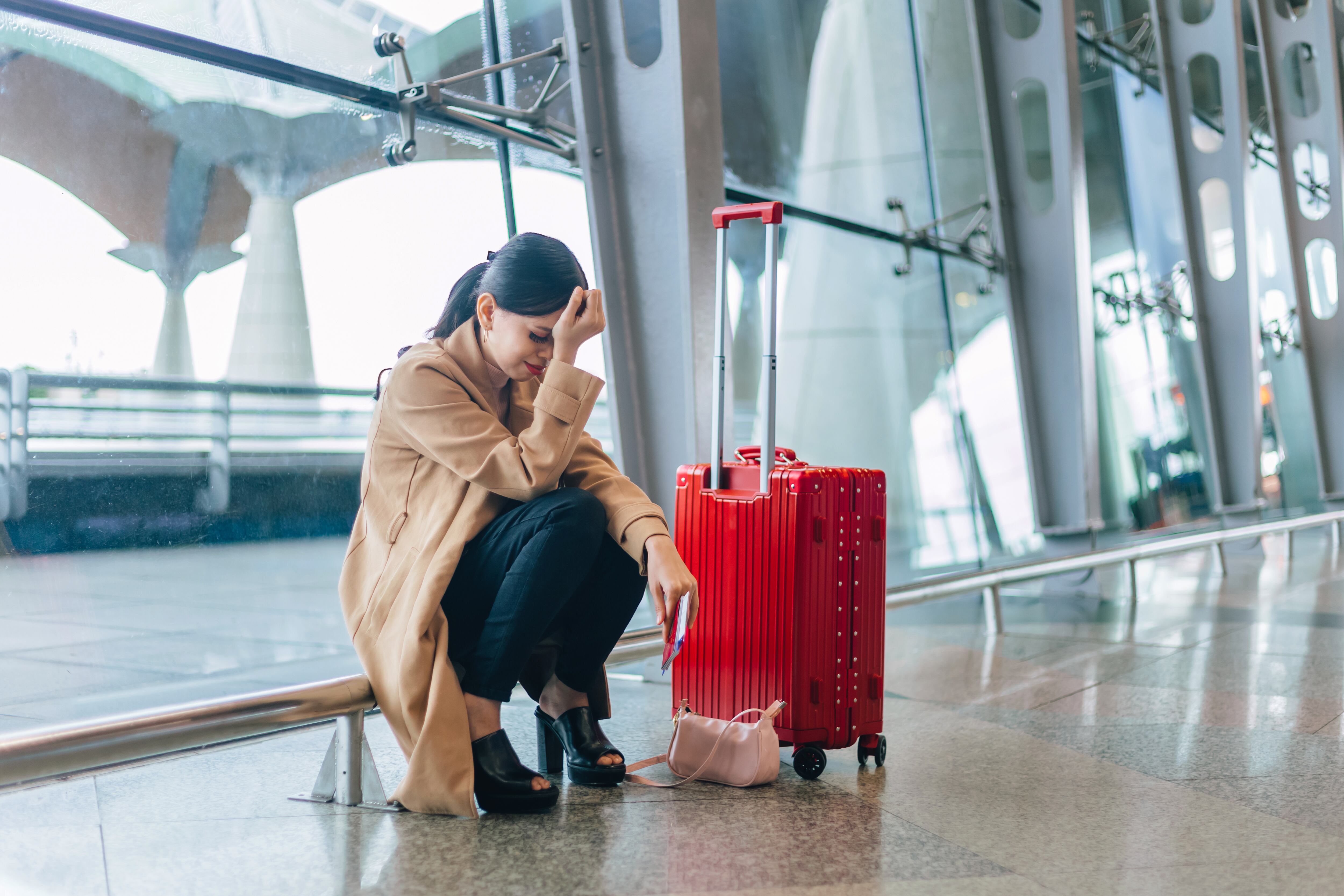 Sad and tired woman sitting in the airport - missed or cancelled flight concept