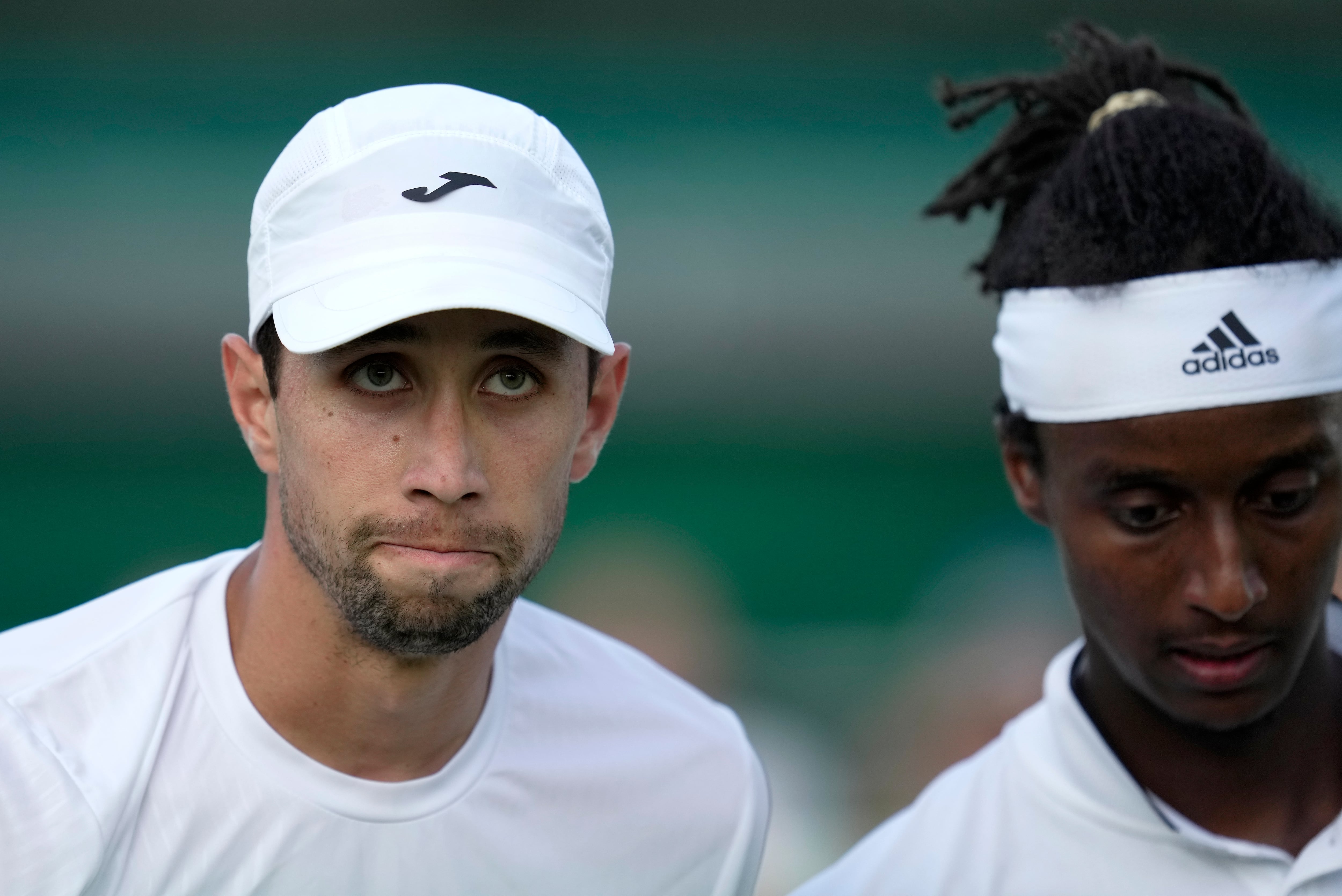 Colombia's Daniel Elahi Galan, left, smiles after beating Sweden's Mikael Ymer, right, in a men's singles match on day five of the Wimbledon tennis championships in London, Friday, July 7, 2023. (AP Photo/Kin Cheung)