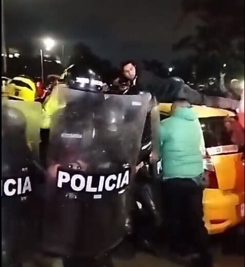 Uno de los taxistas se subió en el techo de su carro para evitar que fuera inmovilizado por la Policía.