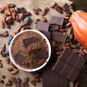 Detail of cocoa fruit with pieces of chocolate and cocoa powder on raw cocoa beans.