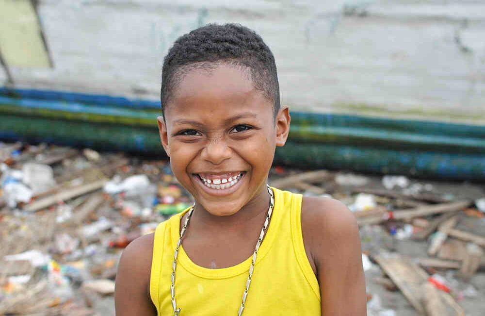 James sonríe en “la playita” que es uno de los lugares mas contaminados del barrio por residuos como el plástico. Foto: Danilo Canguçu