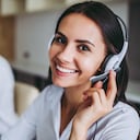¿Cómo puedo ayudarte? Hermosos trabajadores del centro de llamadas con auriculares están trabajando en una oficina moderna.