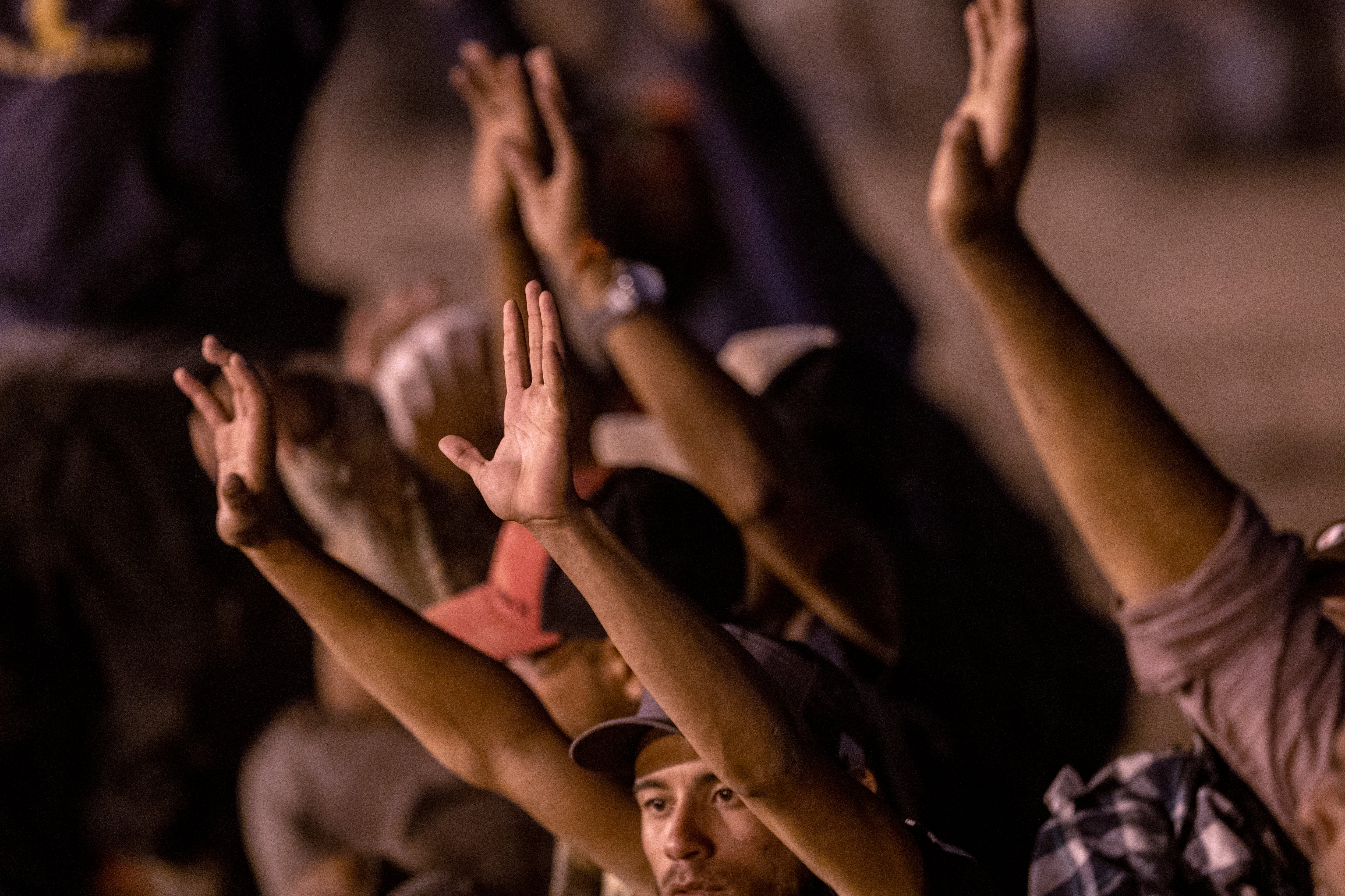 Inmigrantes rezan mientras esperan ser procesados por agentes fronterizos de EE. UU. para solicitar asilo después de cruzar desde México el 9 de mayo de 2023 en El Paso, Texas.