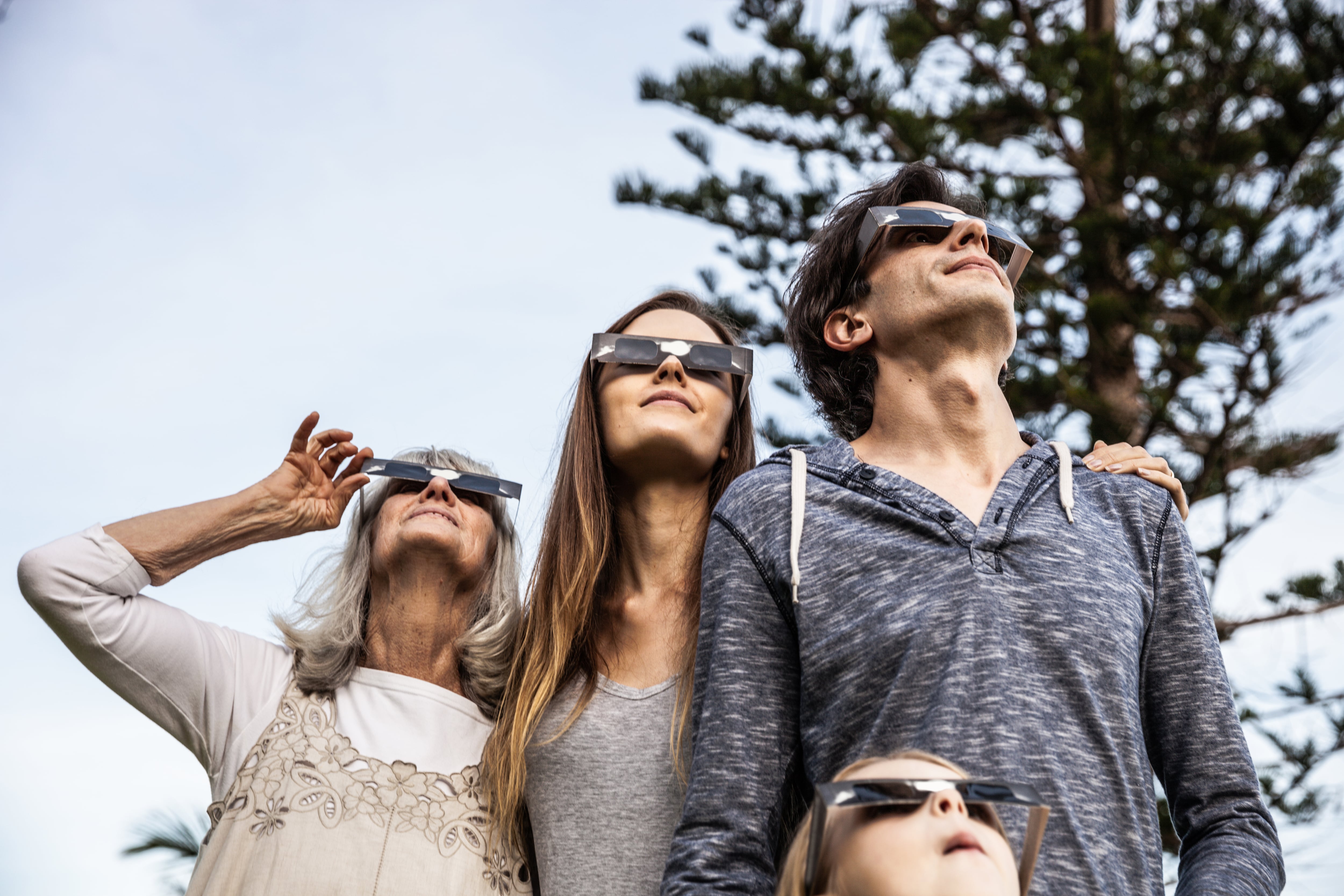 Familia viendo un eclipse con protección en los ojos