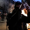 A protester takes a selfie next to a fire during a demonstration after the French government pushed a pensions reform through parliament without a vote, using the article 49,3 of the constitution, in Lyon on March 16, 2023. - The French president on March 16 rammed a controversial pension reform through parliament without a vote, deploying a rarely used constitutional power that risks inflaming protests. The move was an admission that his government lacked a majority in the National Assembly to pass the legislation to raise the retirement age from 62 to 64. (Photo by OLIVIER CHASSIGNOLE / AFP)