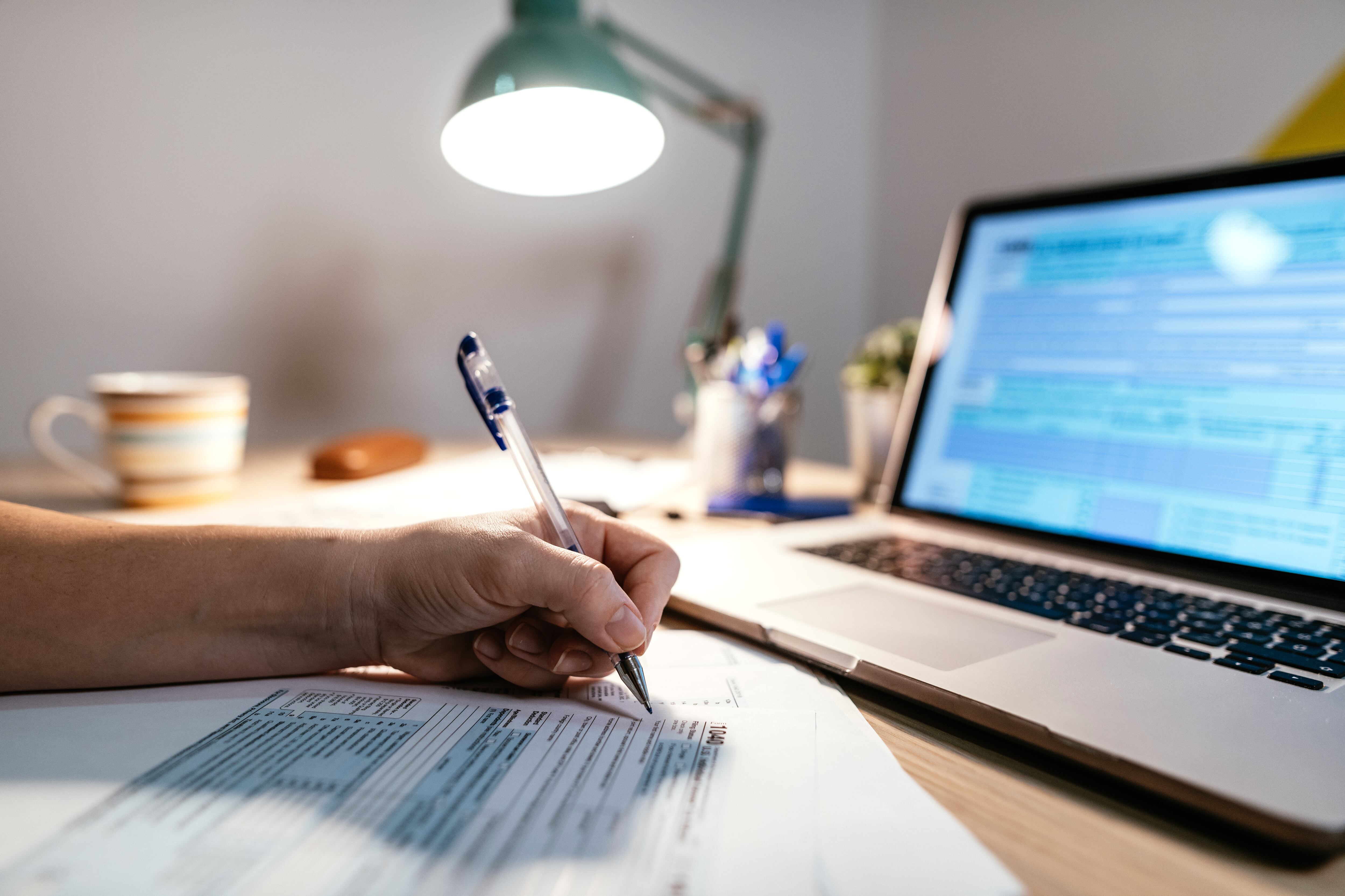 Trabajando desde casa debido al distanciamiento social, la mujer está llenando formulario de impuestos