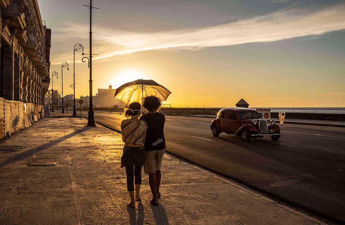 Una pareja que usa máscaras como medida de precaución contra la propagación del nuevo coronavirus camina sobre el malecón al atardecer en La Habana, Cuba, el lunes 31 de agosto de 2020. Las autoridades cubanas introducirán nuevas medidas a partir de mañana martes destinadas a contener la propagación del coronavirus en La Habana como un toque de queda desde las 7 pm hasta las 5 am y que nadie sin un permiso especial podrá entrar o salir de la provincia. Las nuevas medidas durarán al menos 15 días. Foto: Ramón Espinosa / AP  