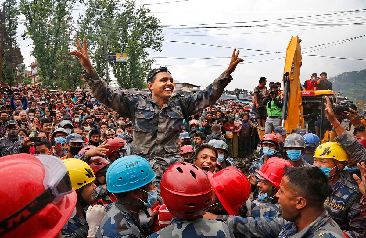 Los policías nepalíes levantan a su comandante y celebran después de que rescataran, junto a equipos de apoyo de Estados Unidos, a un adolescente de un edificio que se derrumbó hace cinco días en Katmandú durante el terremoto en Nepal (AP).