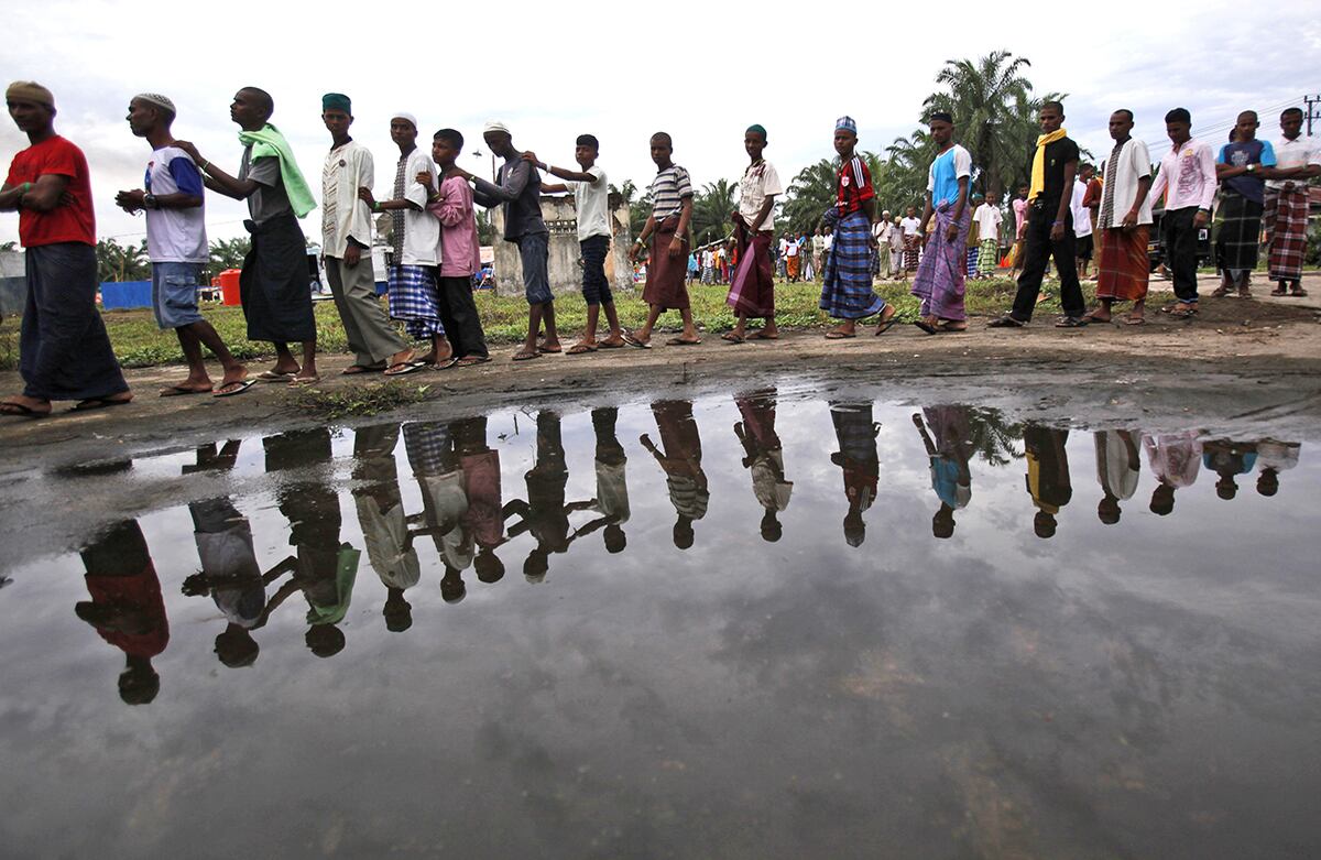 Los migrantes rohinyá hacen fila para obtener alimentos y refugio temporal en Indonesia. (AP/Binsar Bakkara)