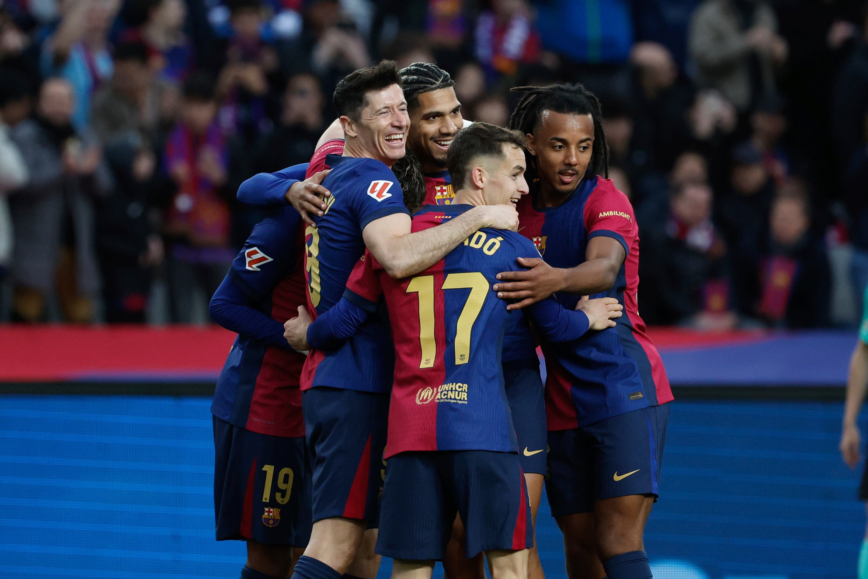 Barcelona's Robert Lewandowski, left, is congratulated after scoring his side's 4th goal during the Spanish La Liga soccer match between Barcelona and Real Sociedad at the Lluis Companys Olympic Stadium in Barcelona, Spain, Sunday, March 2, 2025. (AP Photo/Joan Monfort)