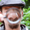 hombre con lupa en la nariz