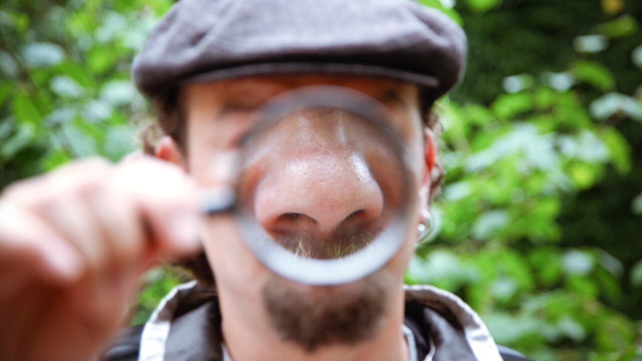 hombre con lupa en la nariz