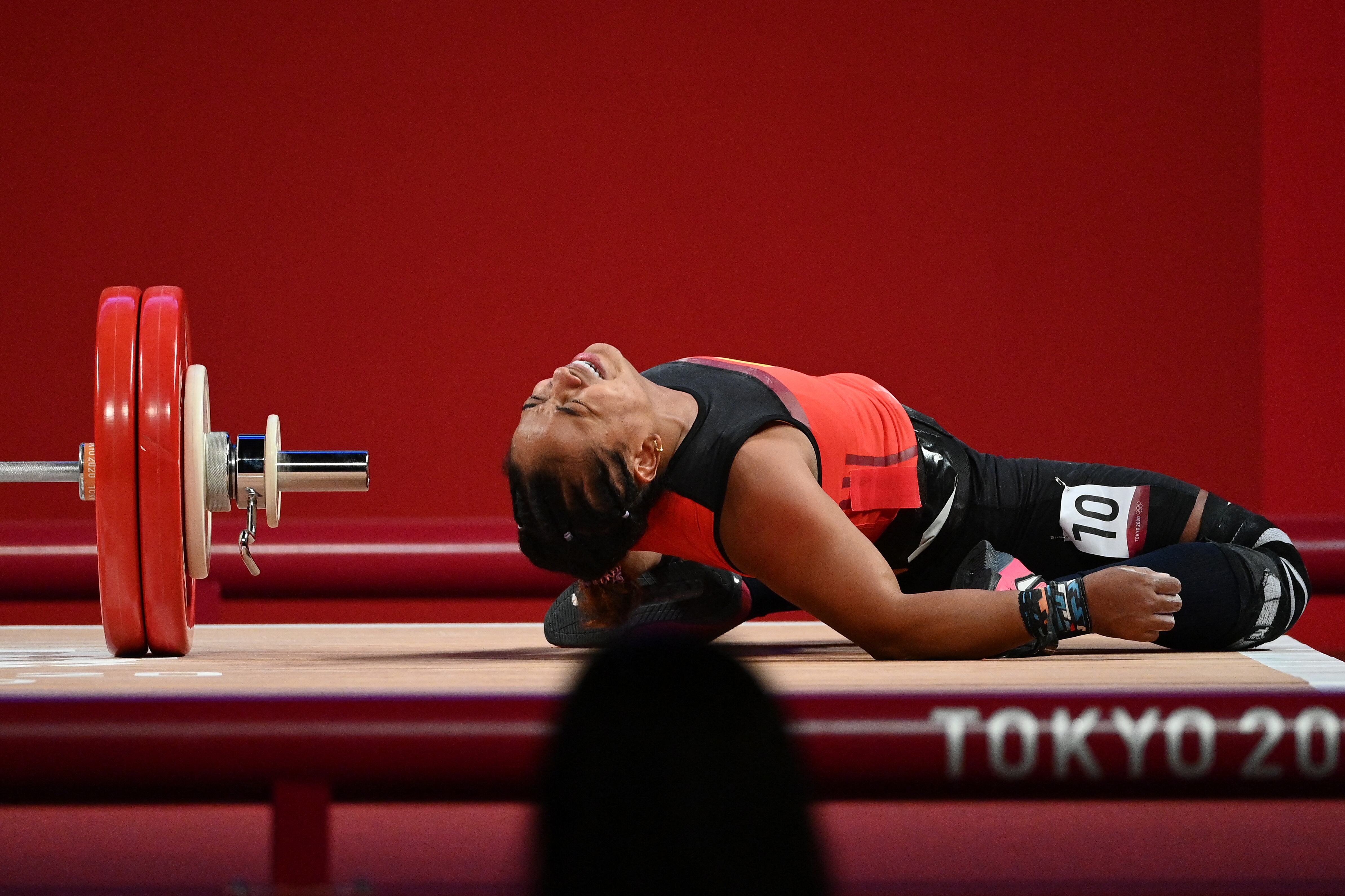 La colombiana Mercedes Isabel Pérez Tigrero reacciona durante la competencia de halterofilia femenina de 64 kg durante los Juegos Olímpicos de Tokio 2020 en el Foro Internacional de Tokio en Tokio el 27 de julio de 2021 (Foto de Vincenzo PINTO / AFP).