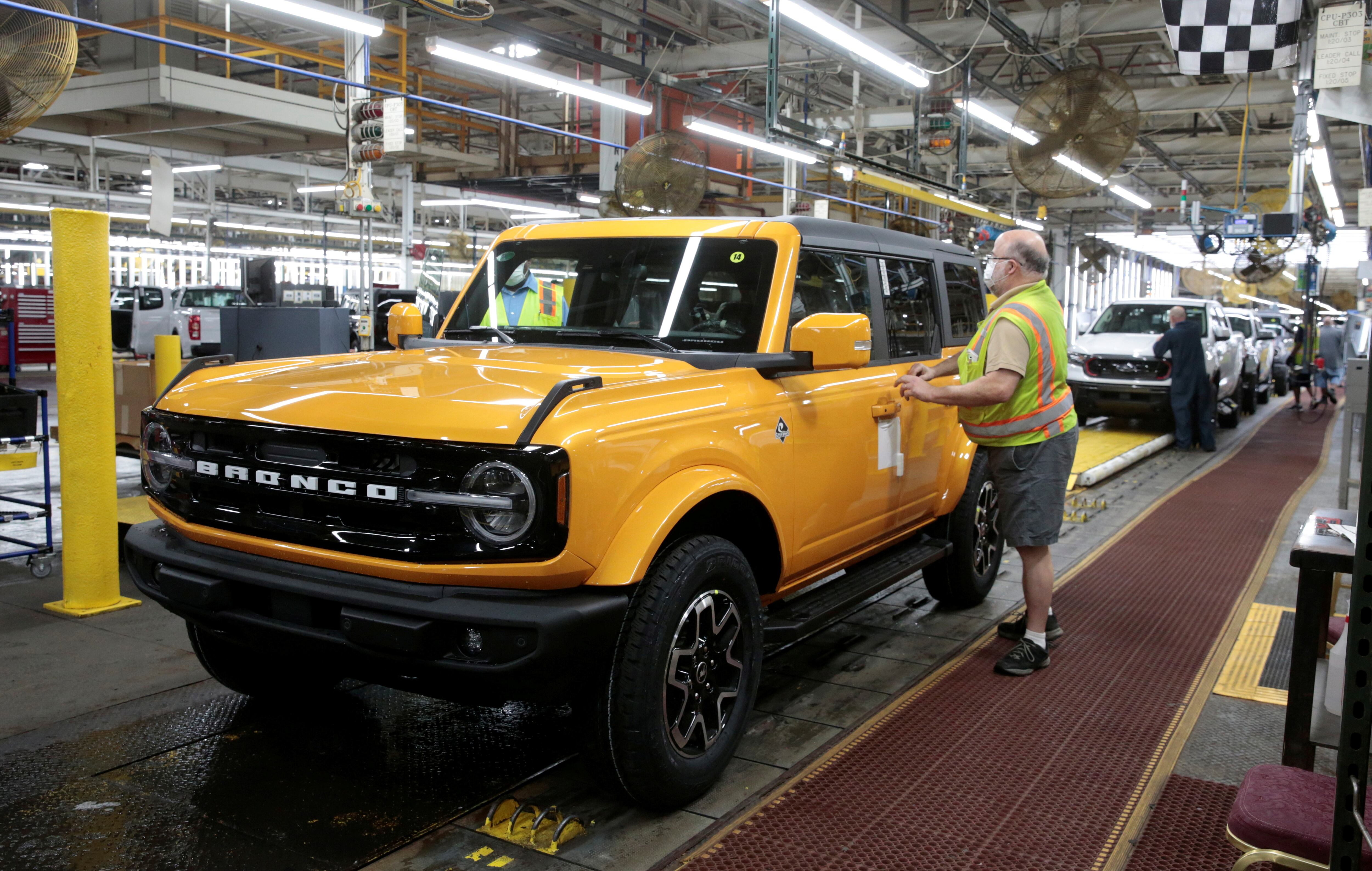 FOTO DE ARCHIVO: Un trabajador de ensamblaje de Ford Motor agrega una calcomanía a una SUV Ford 2021 Bronco terminada en la línea de ensamblaje en la Planta de Ensamblaje de Michigan en Wayne, Michigan, EE. UU. REUTERS / Rebecca Cook / Foto de archivo