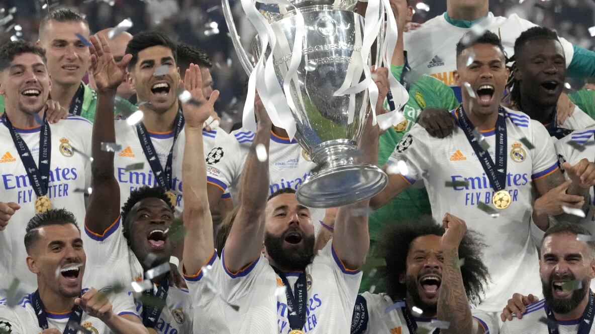 Real Madrid's Karim Benzema lifts the trophy as players celebrate winning the Champions League final soccer match between Liverpool and Real Madrid at the Stade de France in Saint Denis near Paris, Saturday, May 28, 2022. (AP/Frank Augstein)