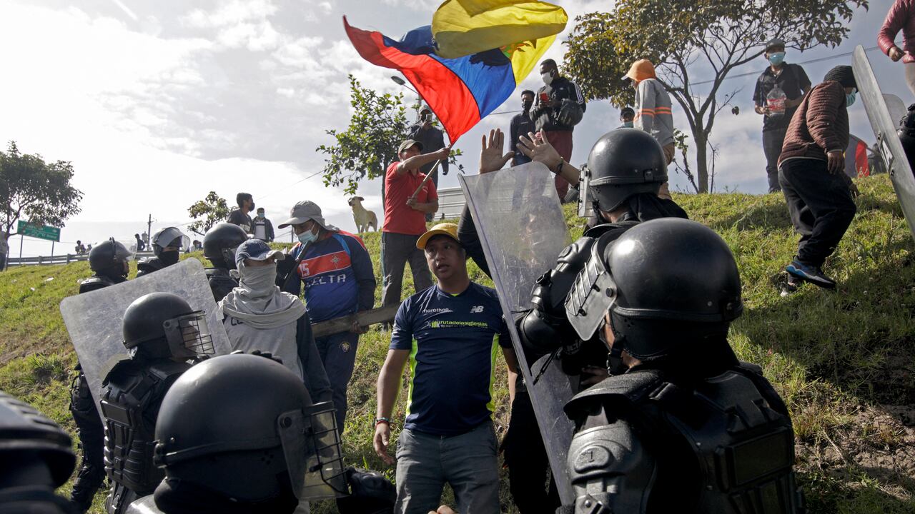 La policía antidisturbios se enfrenta a un manifestante en un bloqueo de carretera en la carretera Ruta Viva, que conduce al aeropuerto Mariscal Sucre, en el marco de protestas lideradas por indígenas contra los altos precios del combustible y el costo de vida, en Quito el 17 de junio de 2022. - Pueblos indígenas, que conforman más de un millón de los 17,7 millones de habitantes de Ecuador, se embarcaron el lunes en una protesta antigubernamental abierta a la que desde entonces se han sumado estudiantes y otros grupos descontentos. (Foto por Cristina Vega RHOR / AFP)