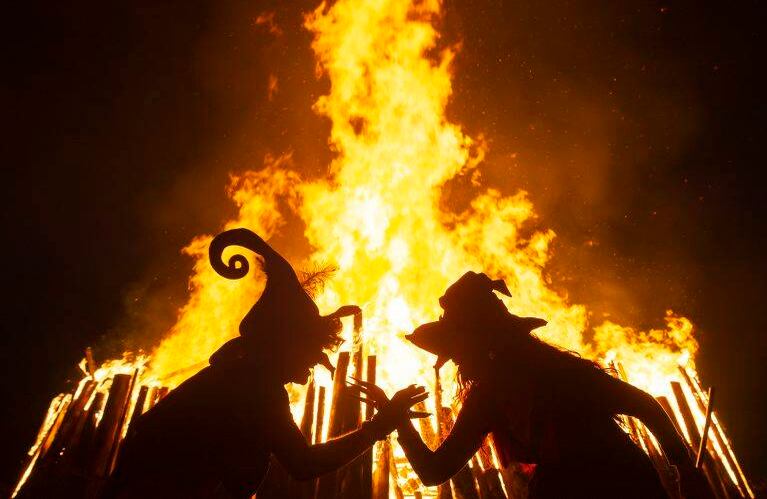 30 de abril - Mujeres vestidas como brujas bailan frente al fuego durante la noche de Walpurgis en Erfurt, Alemania. FOTO:  Jens Meyer / AP