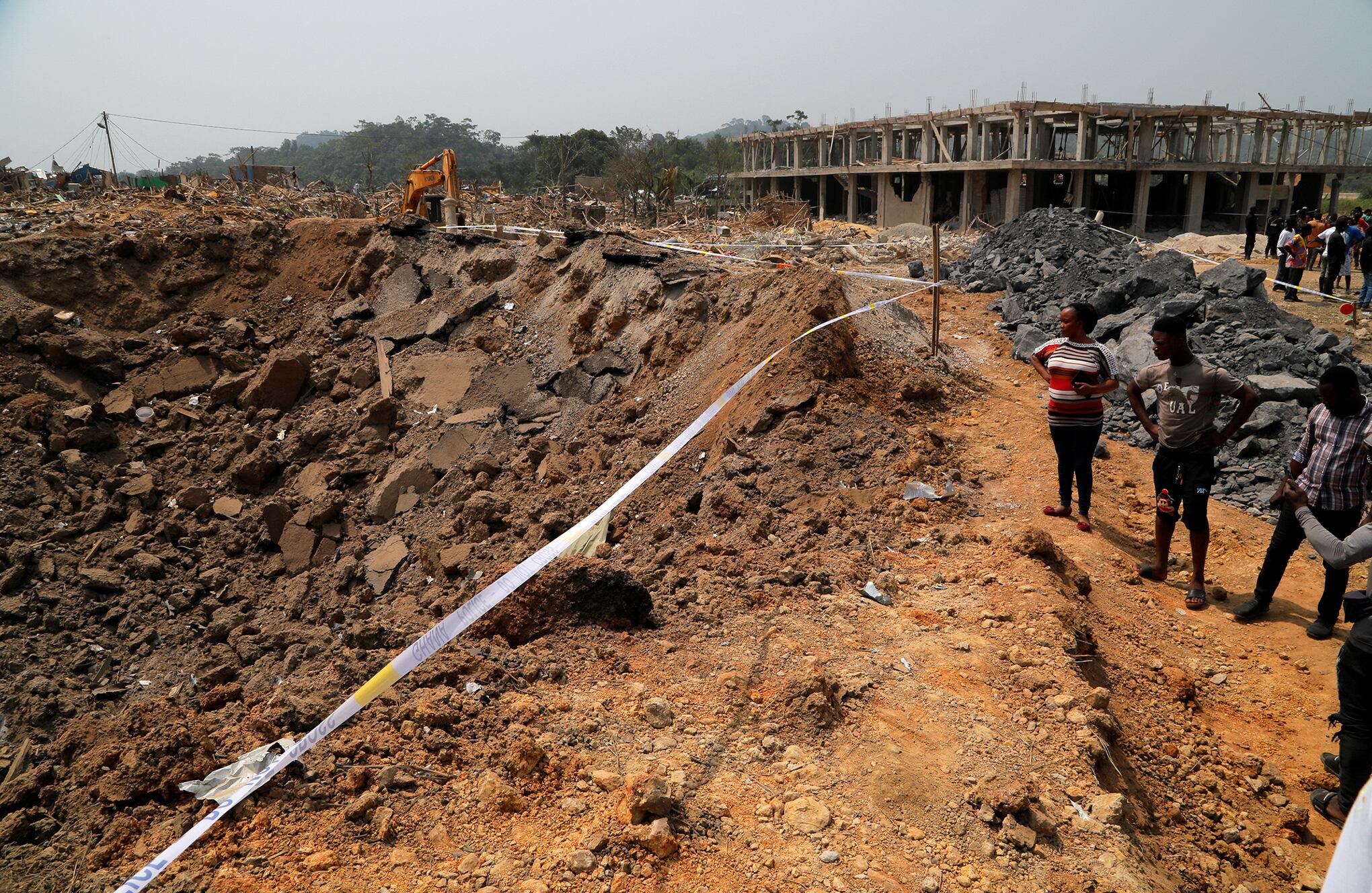 La gente observa los daños causados cuando un vehículo que transportaba explosivos mineros detonó a lo largo de una carretera en Apiate, Ghana. Foto REUTERS/Francis Kokoroko