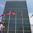 (FILES) In this file photo people walk past flags outside the United Nations headquarters on May 20, 2021 in New York City. - US President Joe Biden, whose international reputation has taken a hit after the chaotic withdrawal from Afghanistan, is upping the number of major diplomatic meetings this fall as he strives to boost alliances to counter China. The White House said on September 13, 2021 Biden will travel to New York on September 21, 2021 to address the United Nations General Assembly.The world's largest diplomatic meeting, which was held virtually in 2020 due to the coronavirus pandemic, will be held this year with a hybrid in-person-virtual format. (Photo by Angela Weiss / AFP)