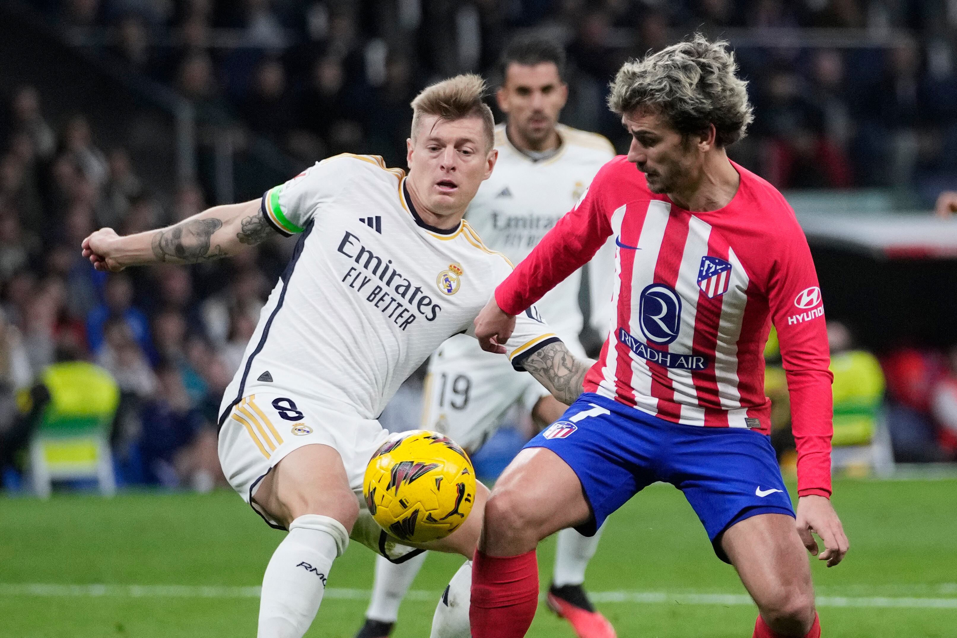 Antoine Griezmann, del Atlético de Madrid, derecha, y Toni Kroos, del Real Madrid, disputan el balón durante el partido de fútbol de la Liga española entre el Real Madrid y el Atlético de Madrid en el estadio Santiago Bernabeu de Madrid, España, el domingo 4 de febrero de 2024. (Foto AP /Bernat Armangué)