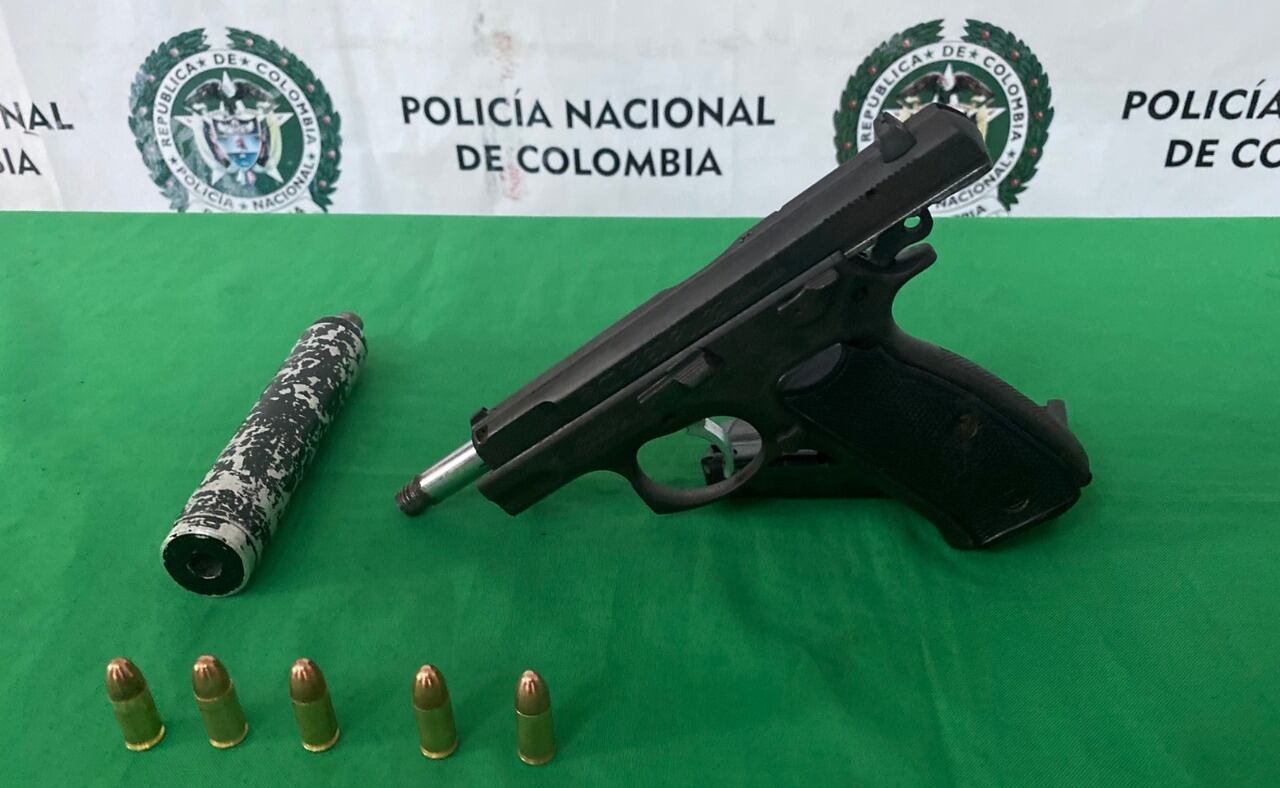 Arma de fuego con silenciador encontrada en el taxi.