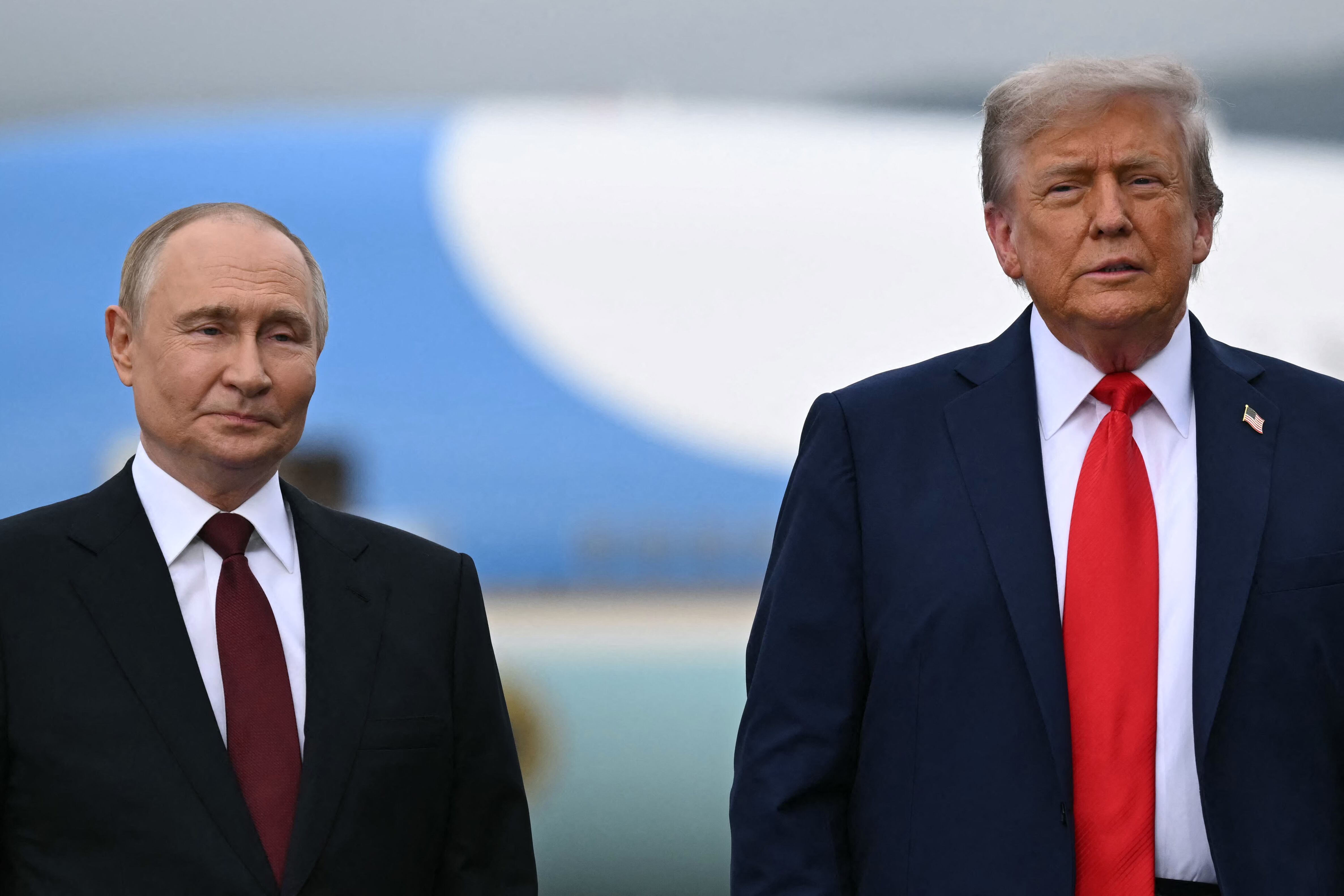 El presidente estadounidense Donald Trump (der.) y el presidente ruso Vladimir Putin posan en un podio en la pista tras su llegada a la Base Conjunta Elmendorf-Richardson en Anchorage, Alaska, el 15 de agosto de 2025.