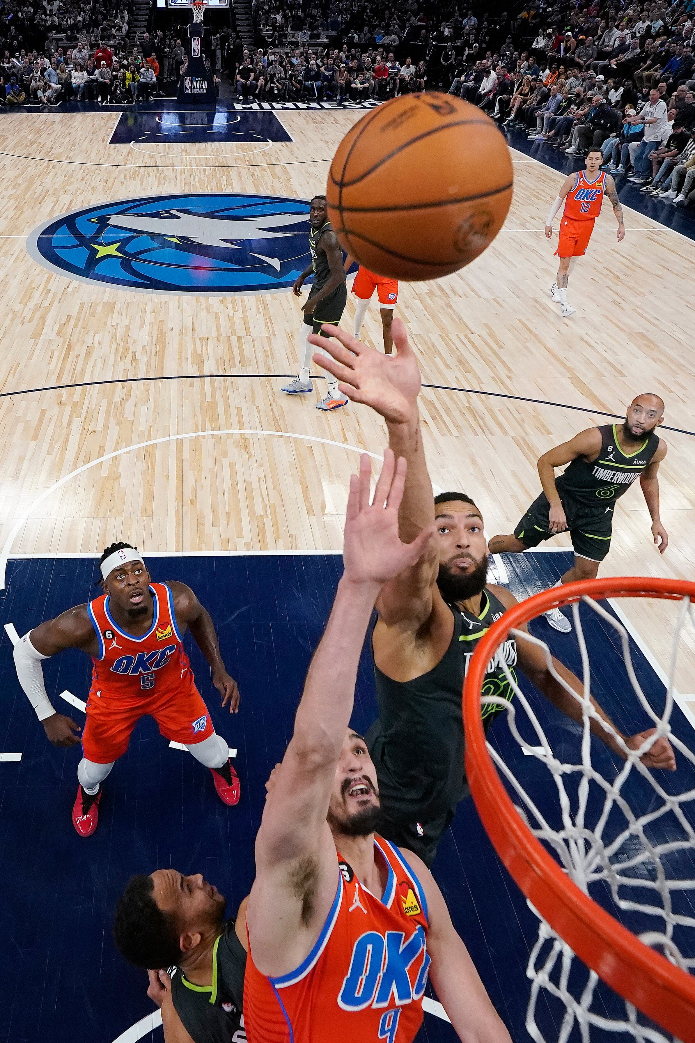 Oklahoma City Thunder forward Dario Saric, front, and Minnesota Timberwolves center Rudy Gobert, right, reach for a rebound during the first half of an NBA basketball play-in tournament game Friday, April 14, 2023, in Minneapolis. (AP Photo/Abbie Parr)