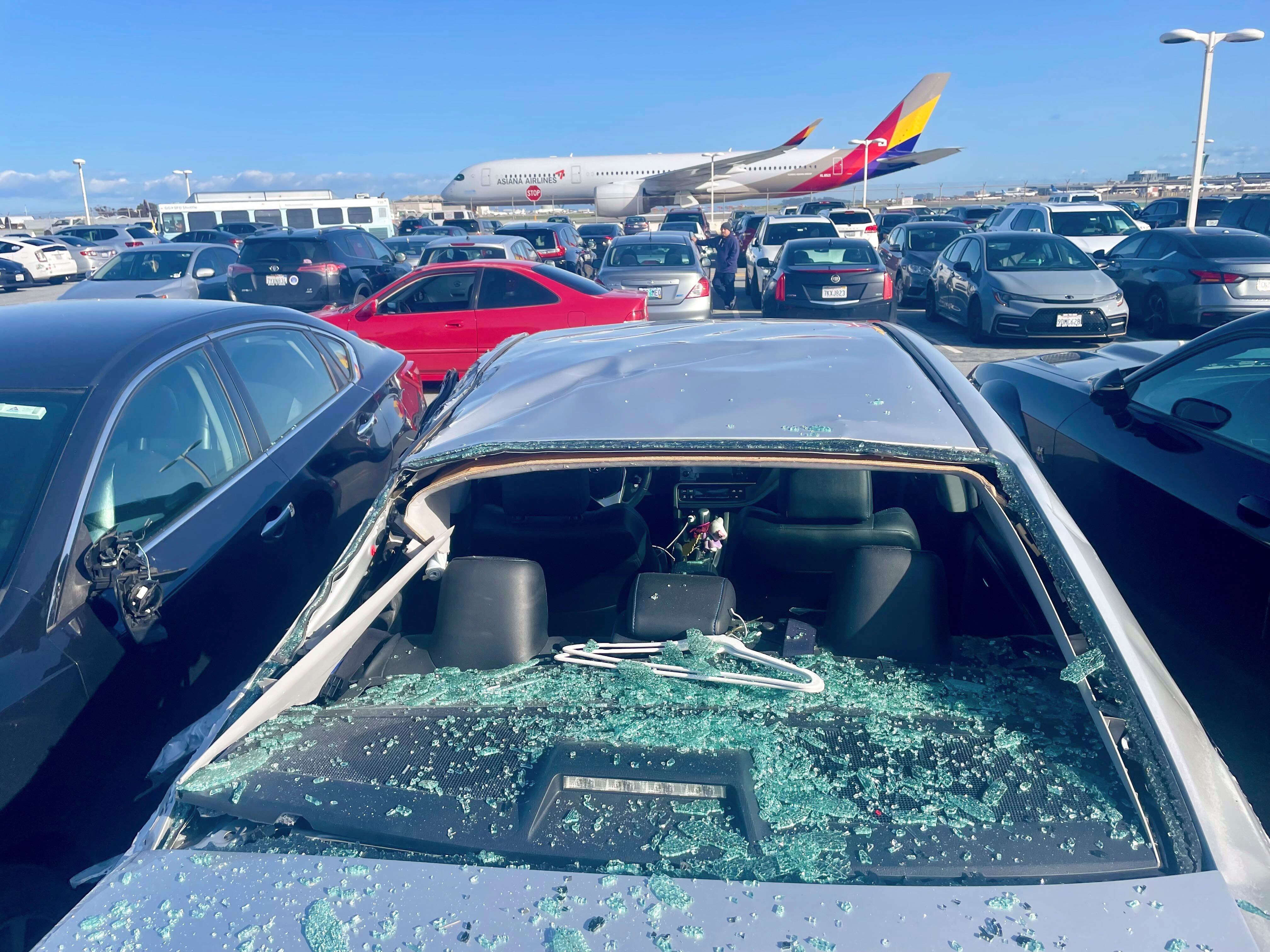 Se ven automóviles dañados en un estacionamiento para empleados del aeropuerto después de que los restos de neumáticos de un Boeing 777 aterrizaran sobre ellos en el Aeropuerto Internacional de San Francisco, el jueves 7 de marzo de 2024.
