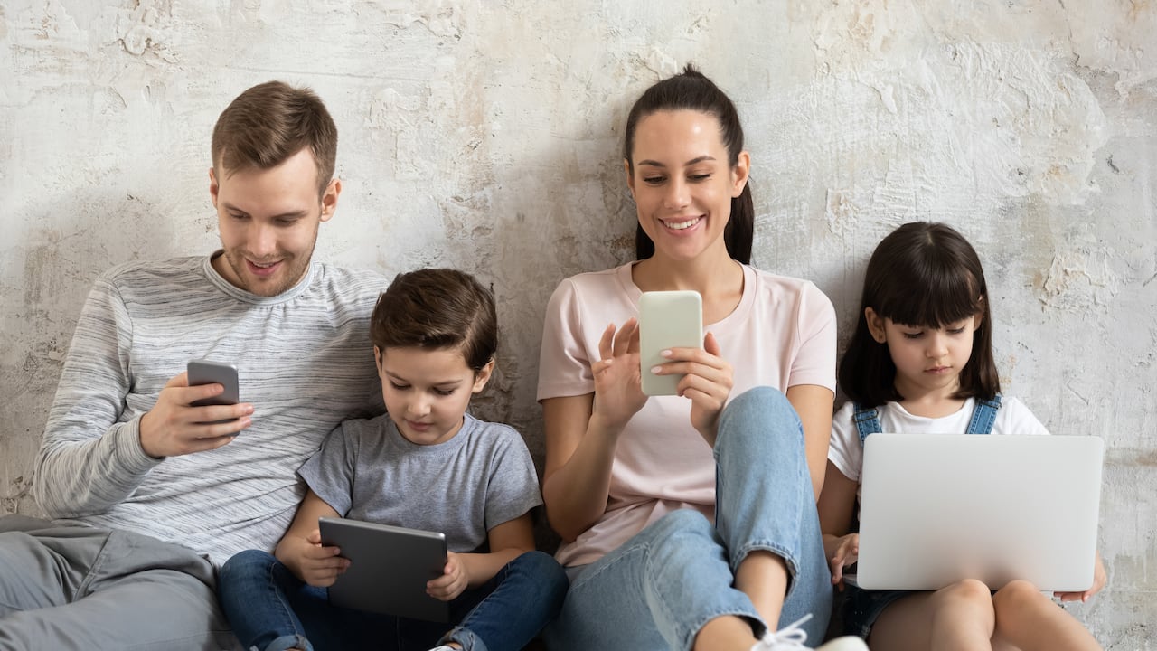 Miembros de una familia, cada uno con un dispositivo. (Imagen de referencia)