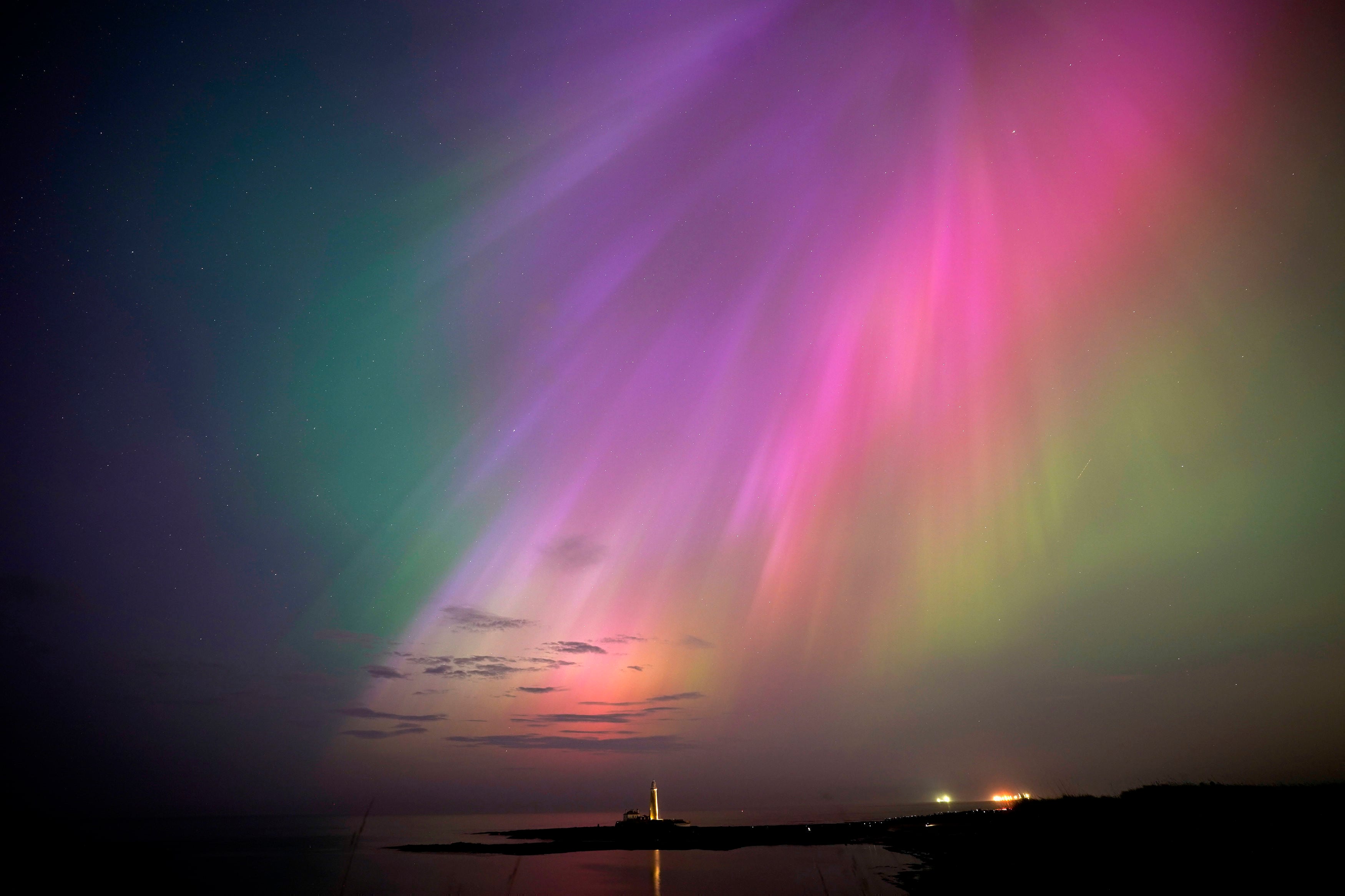 Una aurora boreal brilla en el horizonte sobre el faro de St. Mary en la costa noreste de Inglaterra, el viernes 10 de mayo de 2024. En todo el mundo se reportaron brillantes luces púrpuras, verdes, amarillas y rosadas, con avistamientos en Alemania, Suiza, Londres y Estados Unidos y Canadá.