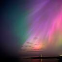 Una aurora boreal brilla en el horizonte sobre el faro de St. Mary en la costa noreste de Inglaterra.