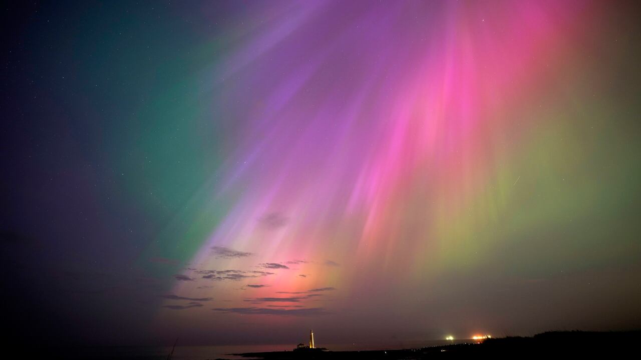 Una aurora boreal brilla en el horizonte sobre el faro de St. Mary en la costa noreste de Inglaterra.